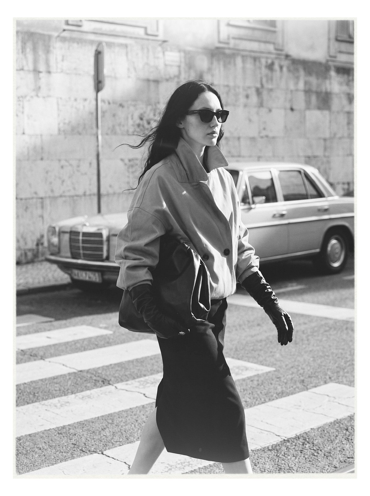 Street editorial: model crossing a cobblestone street