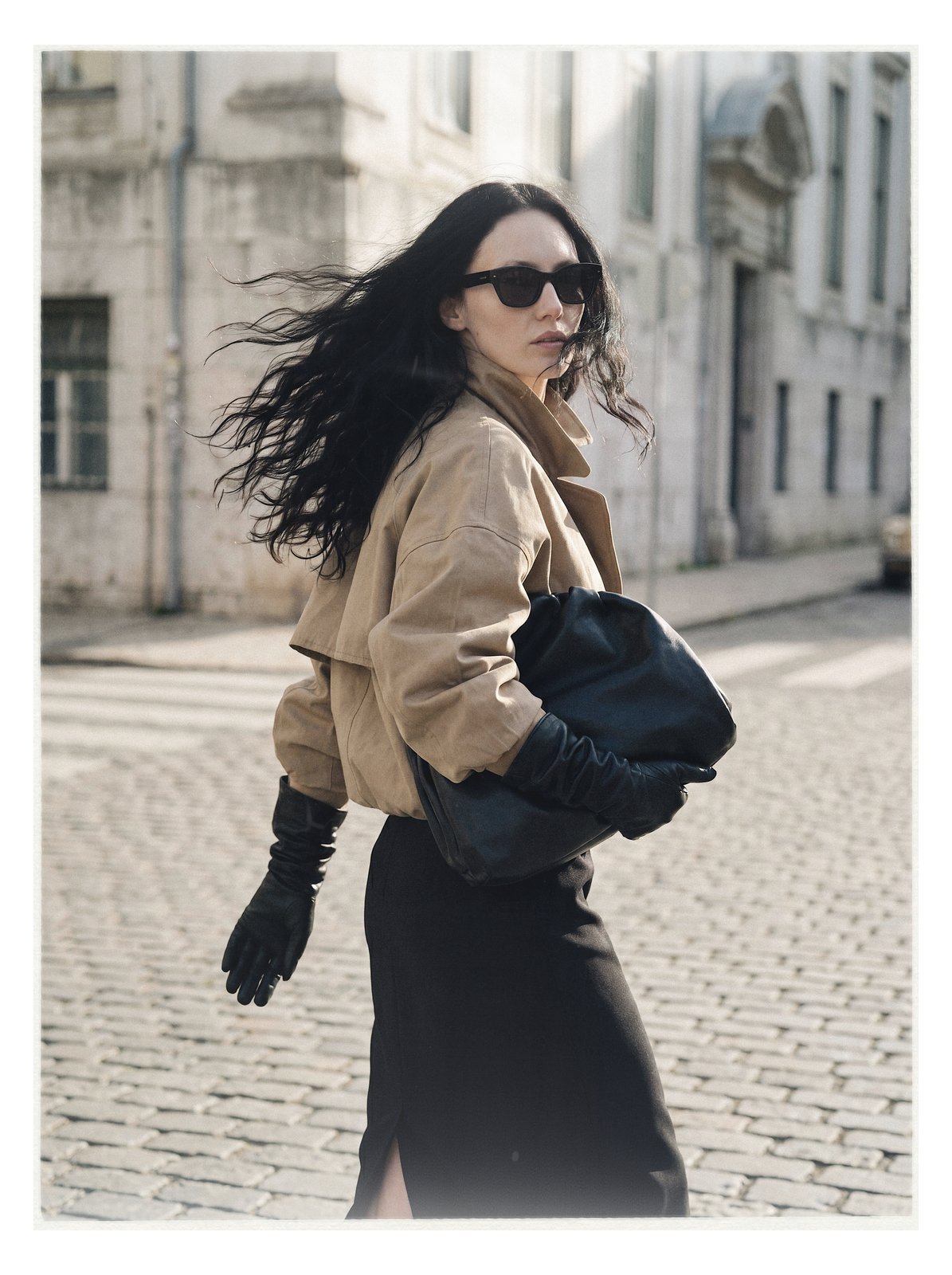 Street editorial: model walking in a beige coat, hair in motion